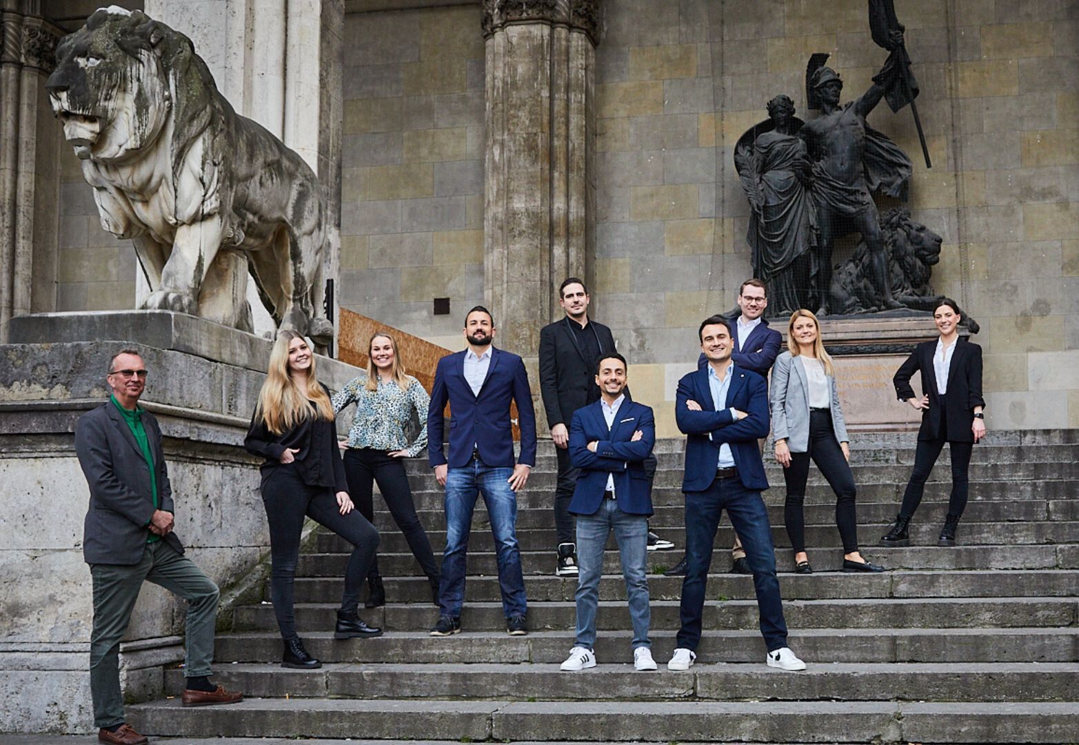 Das Team der ROCKSOLID Personalvermittlung steht auf den Stufen der Feldherrnhalle am Odeonsplatz in München